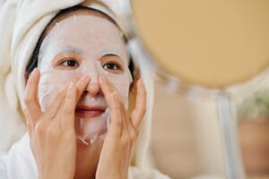 Woman Applying Resurfacing Sheet Mask